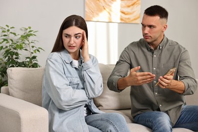 Photo of Husband showing smartphone with proofs to his unfaithful wife at home