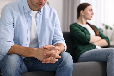 Photo of Offended couple ignoring each other at home, selective focus