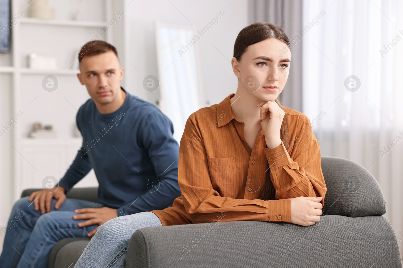 Photo of Upset couple after quarrel at home, selective focus