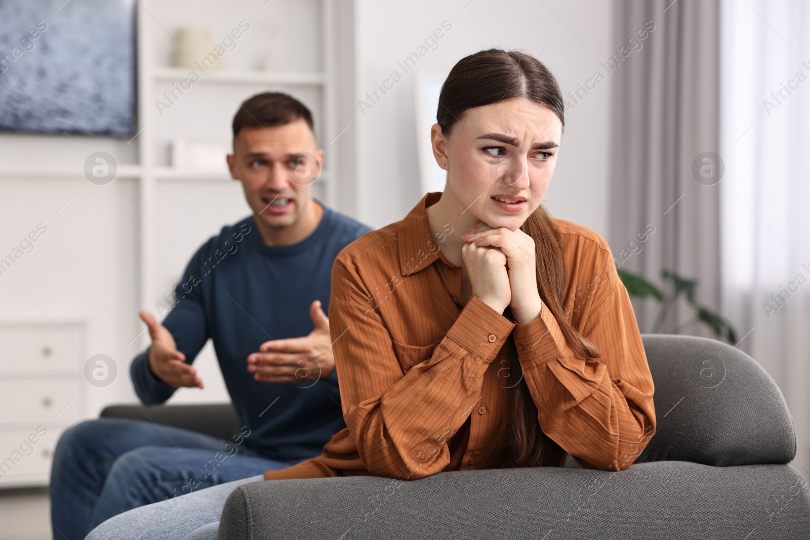 Photo of Upset woman ignoring her husband at home, selective focus