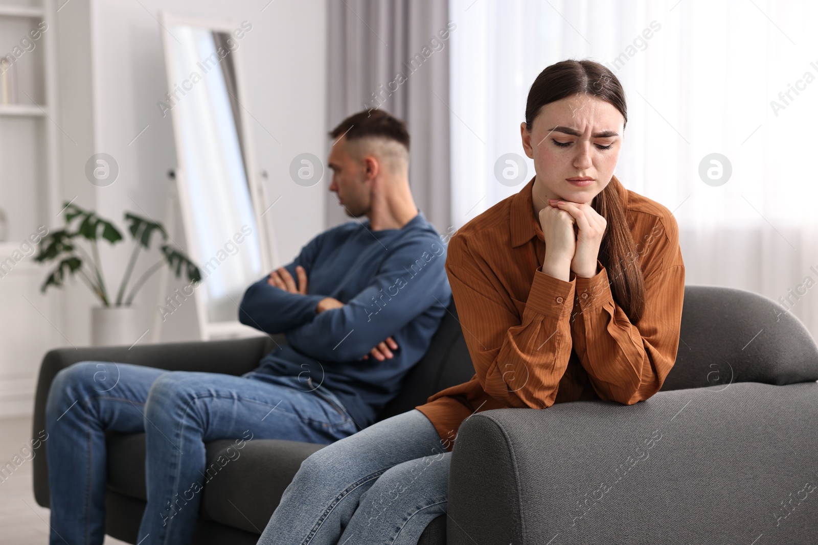 Photo of Offended couple ignoring each other at home, selective focus