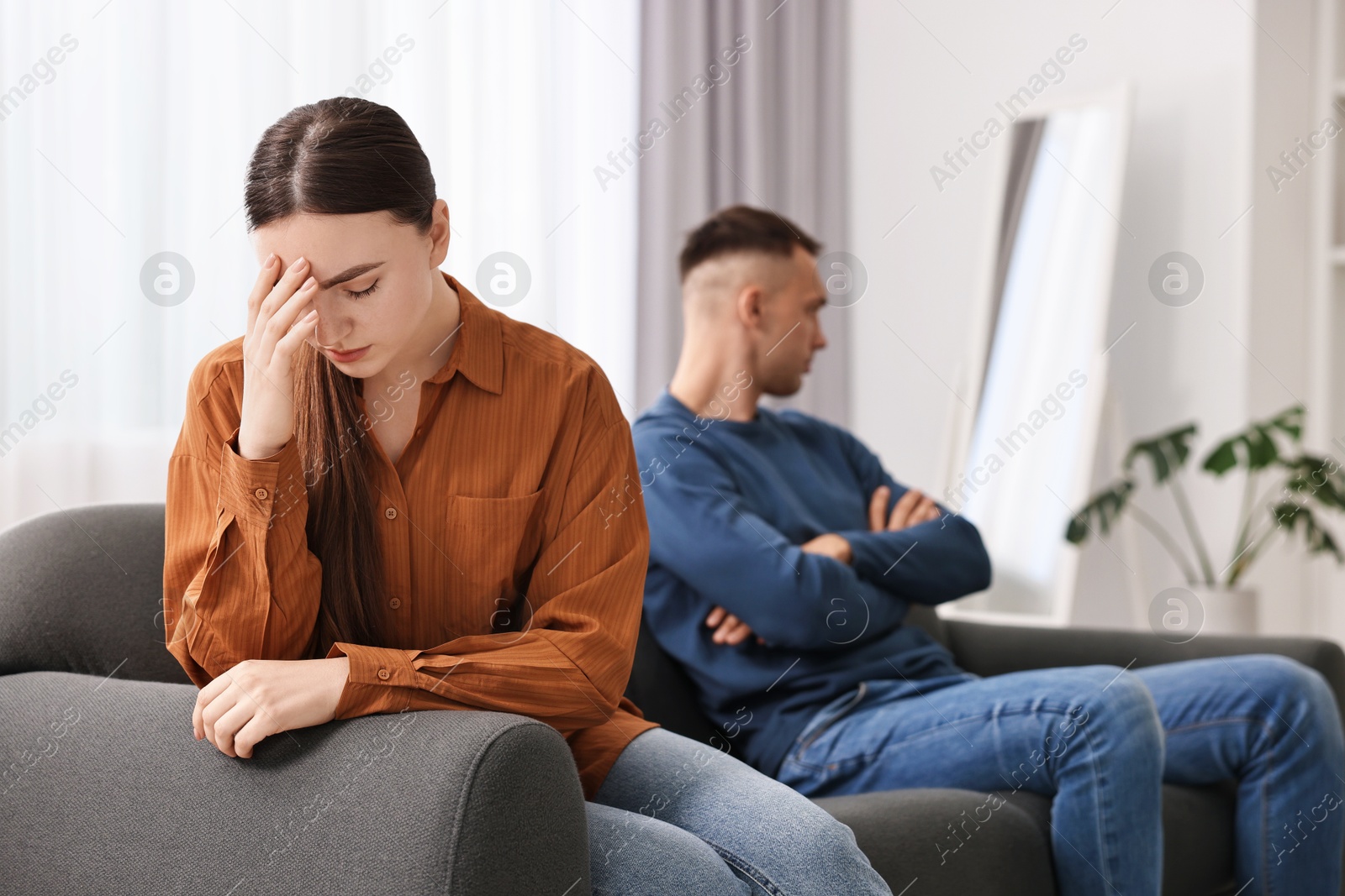 Photo of Offended couple ignoring each other at home, selective focus