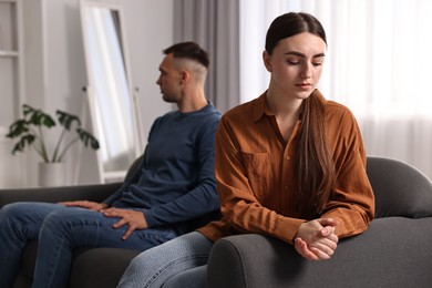 Photo of Offended couple ignoring each other at home, selective focus