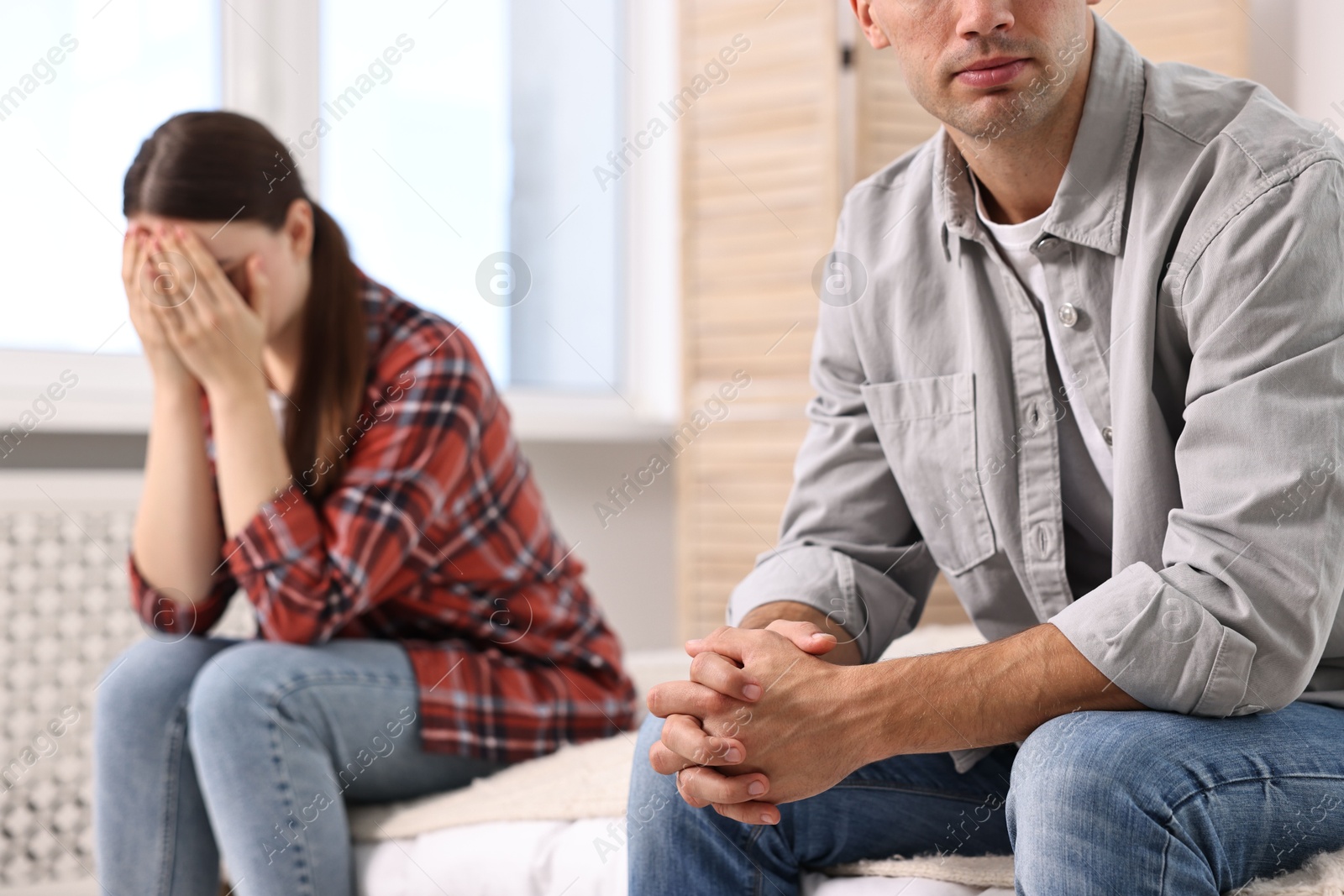 Photo of Offended couple ignoring each other at home, selective focus