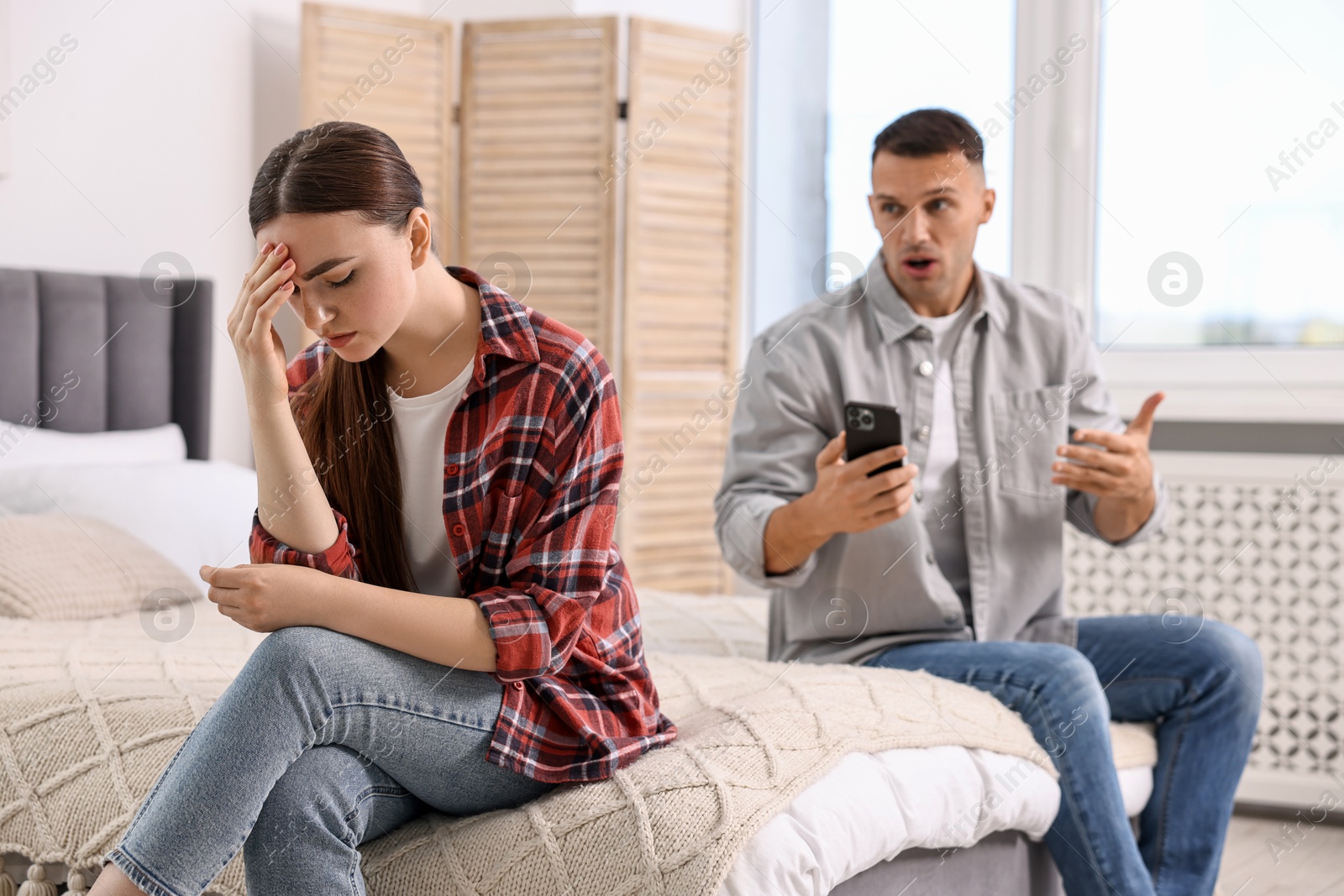 Photo of Upset woman ignoring her husband at home, selective focus