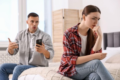 Upset woman ignoring her husband at home, selective focus