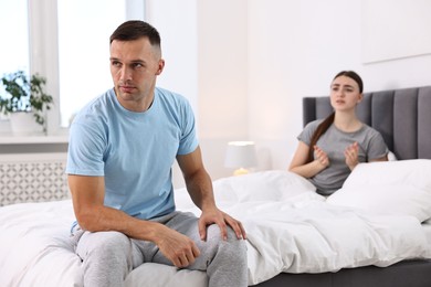 Wife apologizing her husband while he ignoring her in bedroom, selective focus