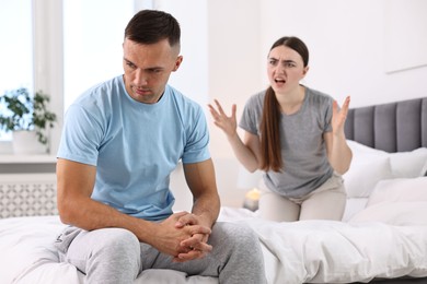 Photo of Husband ignoring his emotional wife in bedroom