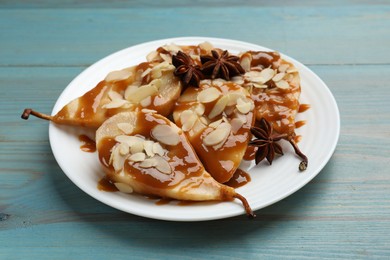 Photo of Delicious pears with caramel sauce, almond flakes and anise stars on light blue wooden table, closeup