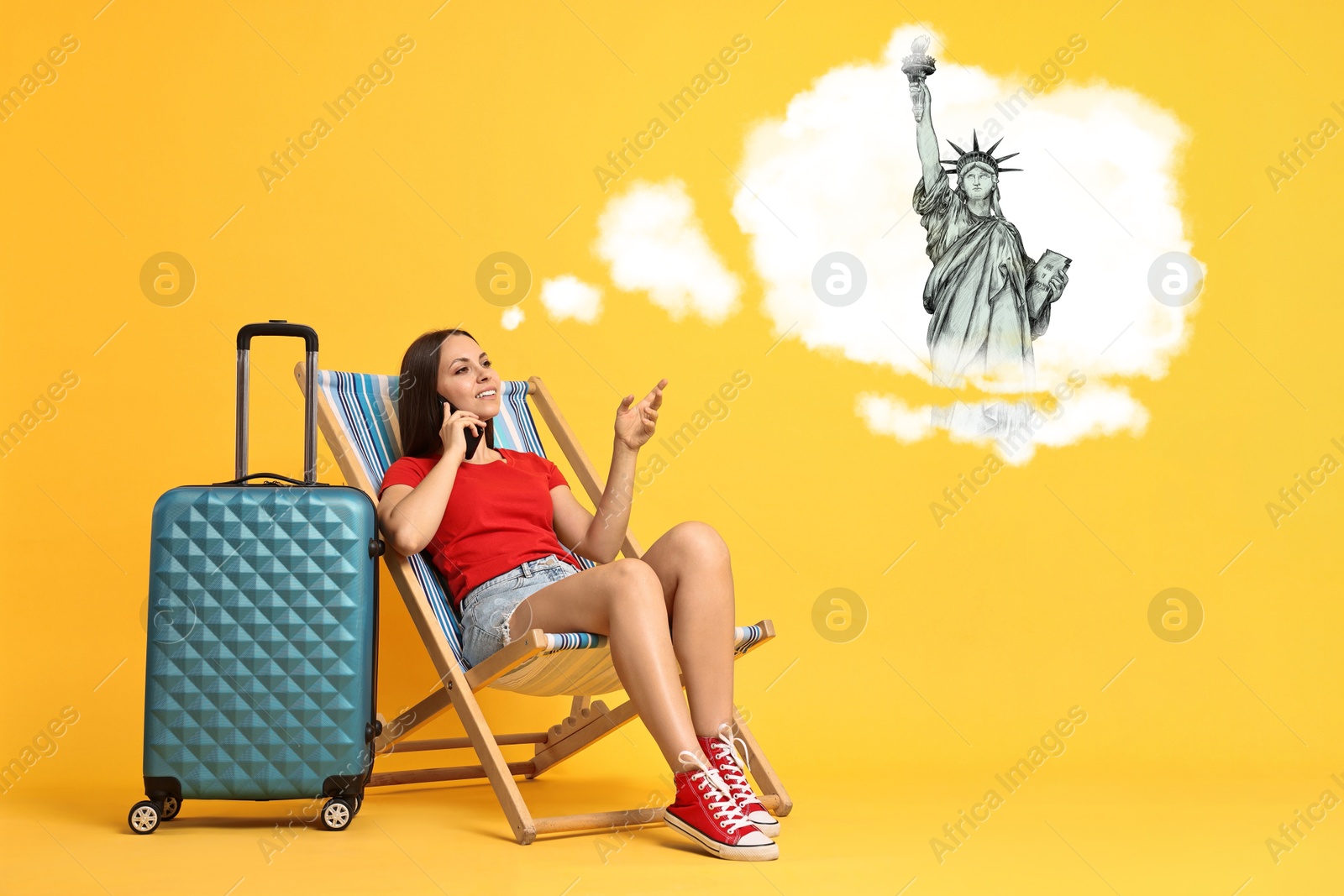 Image of Happy traveler with suitcase talking on phone about journey to USA on orange background. Illustration of Statue of Liberty in thought cloud