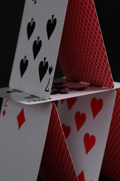 House of playing cards on black background, closeup