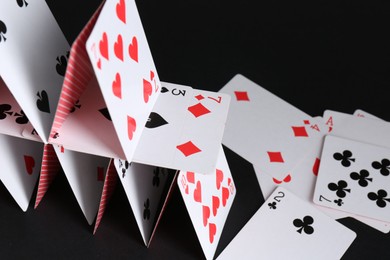 Photo of House of playing cards on black background