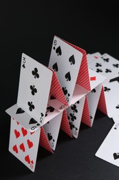 House of playing cards on black background