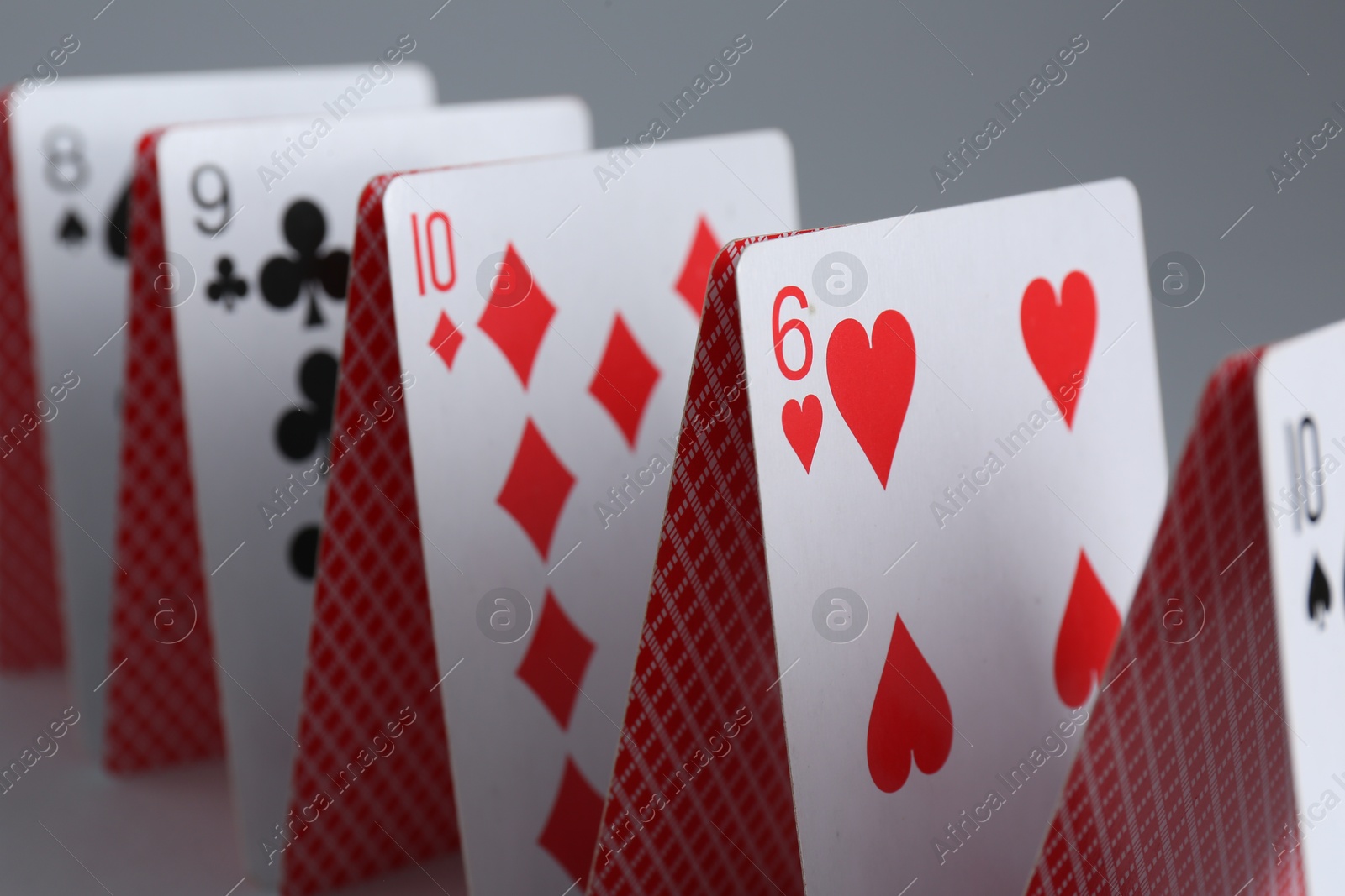 Photo of Row of playing cards on grey background, closeup