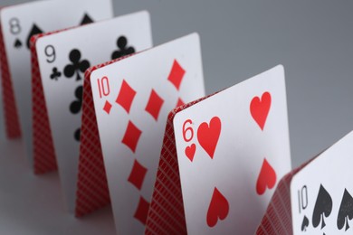 Photo of Row of playing cards on grey background, closeup