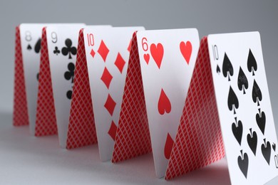 Photo of Row of playing cards on grey background, closeup