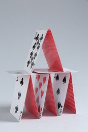 Photo of House of playing cards on light grey background