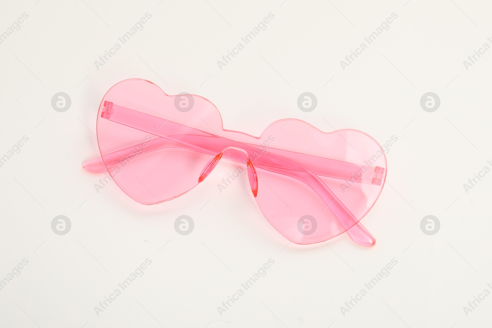 Photo of Stylish heart shaped sunglasses on white background