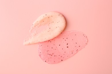 Smears of body scrubs on light pink background, top view