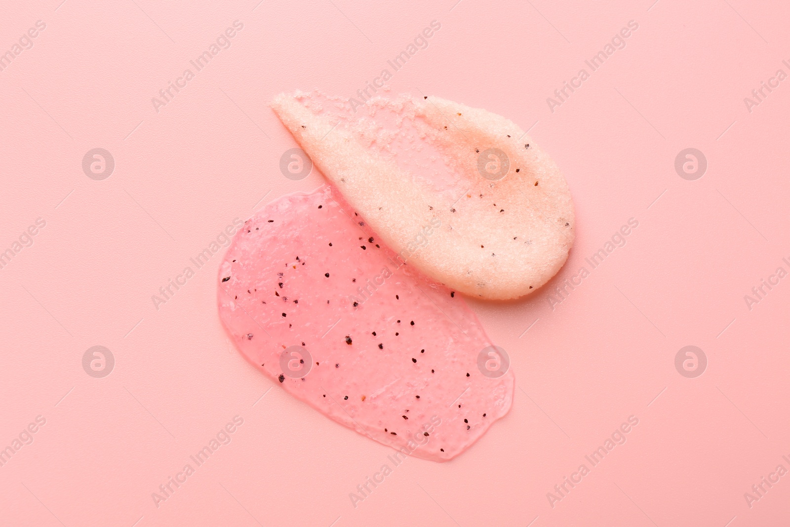 Photo of Smears of body scrubs on light pink background, top view