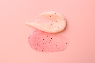 Photo of Smears of body scrubs on light pink background, top view