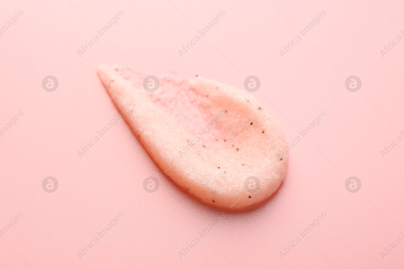 Photo of Smear of body scrub on light pink background, closeup