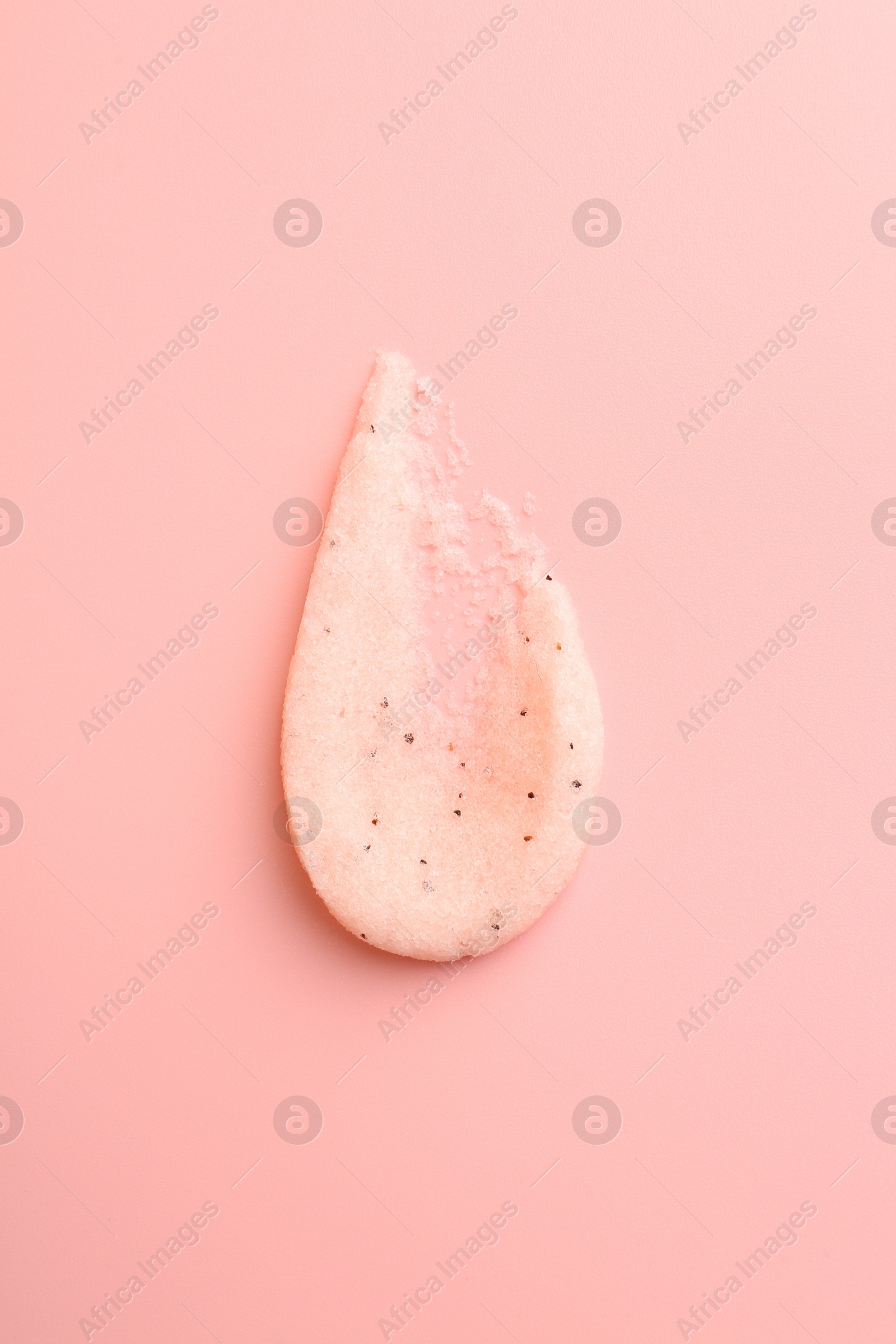 Photo of Smear of body scrub on light pink background, top view