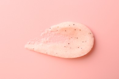 Photo of Smear of body scrub on light pink background, top view