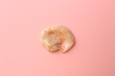 Photo of Smear of body scrub on light pink background, top view