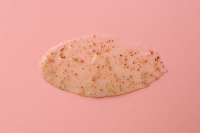 Photo of Smear of body scrub on light pink background, top view