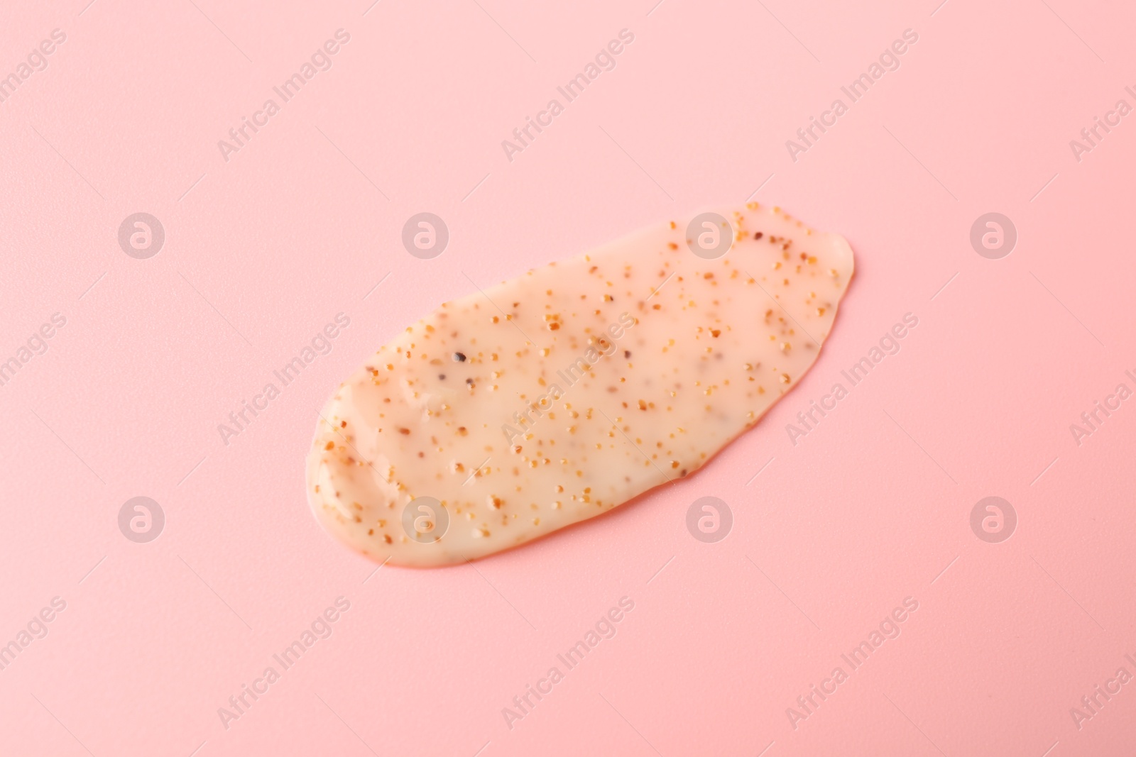 Photo of Smear of body scrub on light pink background, closeup