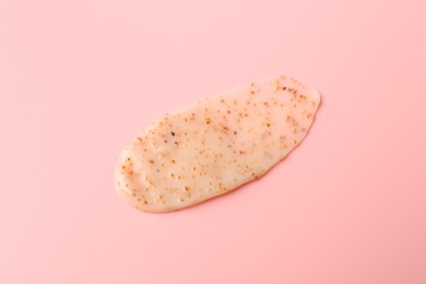 Photo of Smear of body scrub on light pink background, closeup