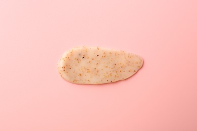 Photo of Smear of body scrub on light pink background, top view