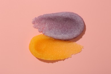 Photo of Smears of body scrubs on light pink background, top view