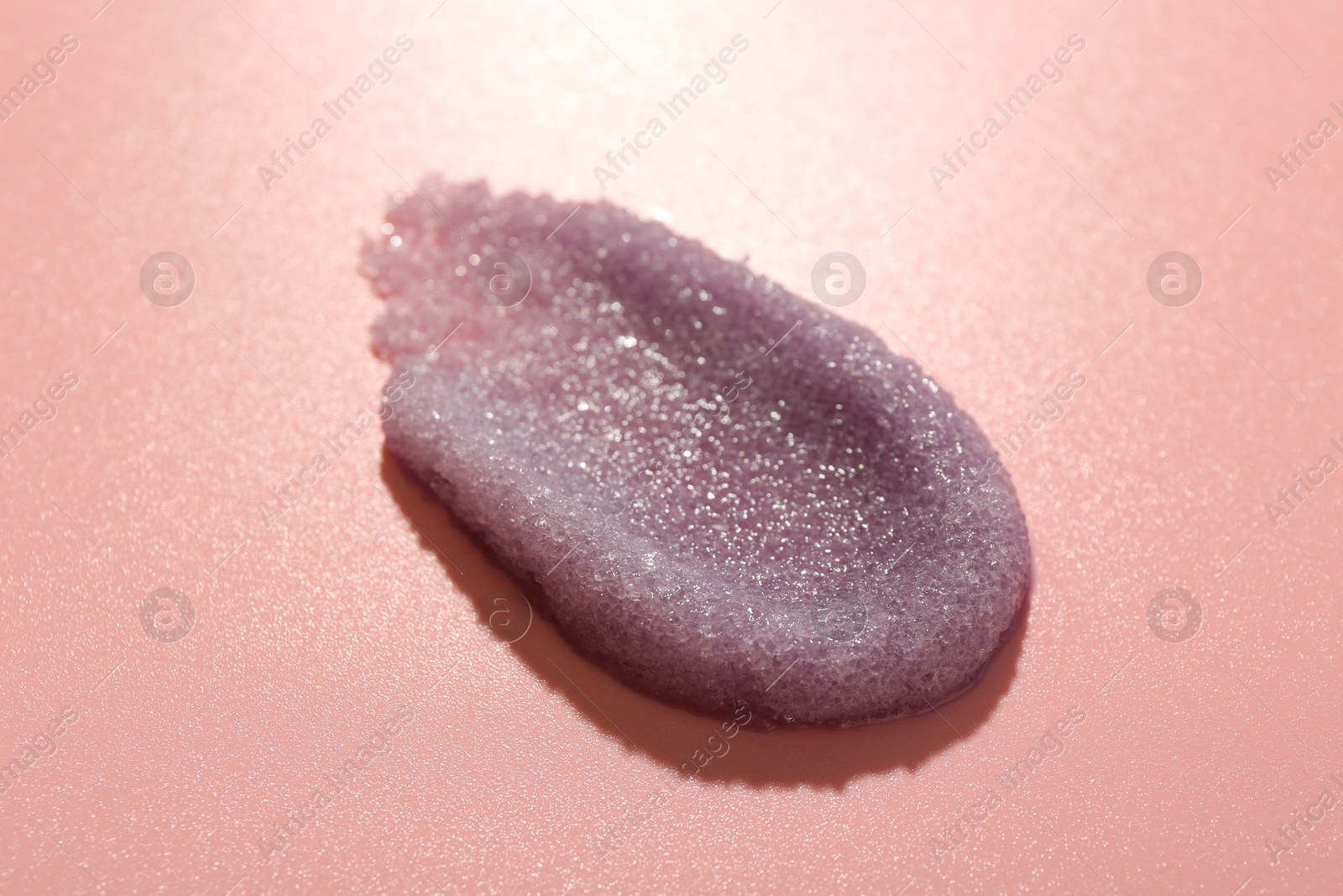 Photo of Smear of body scrub on light pink background, closeup