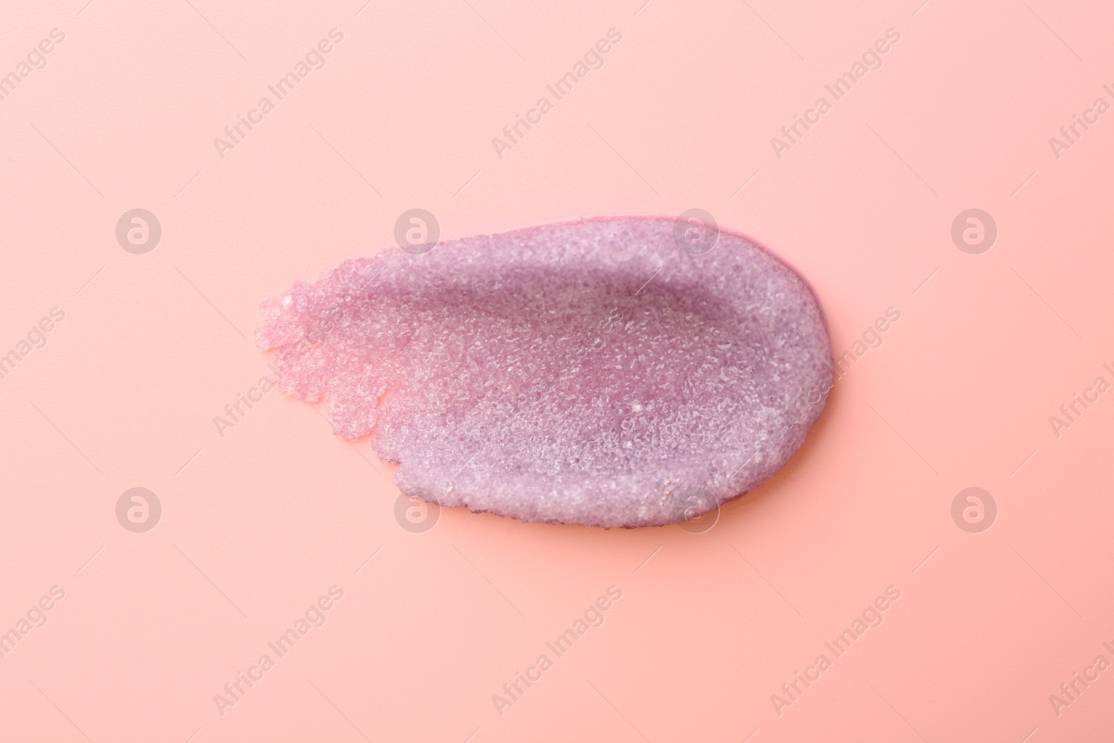 Photo of Smear of body scrub on light pink background, top view