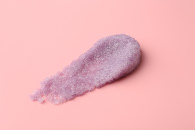 Photo of Smear of body scrub on light pink background, closeup