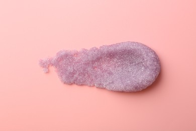 Smear of body scrub on light pink background, top view