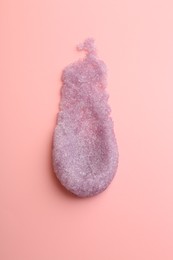 Photo of Smear of body scrub on light pink background, top view