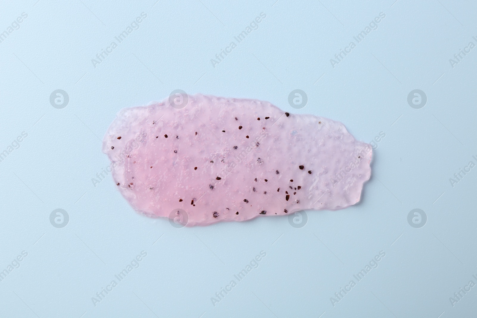 Photo of Smear of body scrub on light blue background, top view