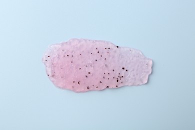 Photo of Smear of body scrub on light blue background, top view