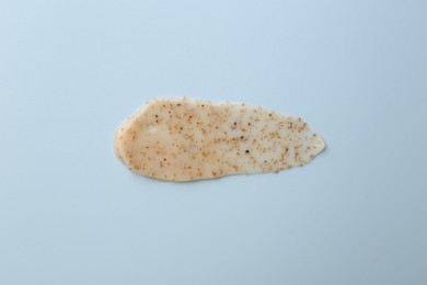 Photo of Smear of body scrub on light blue background, top view