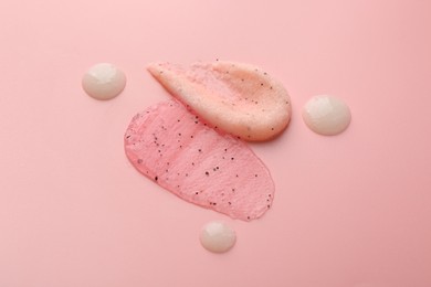 Photo of Smears of body scrubs on light pink background, closeup