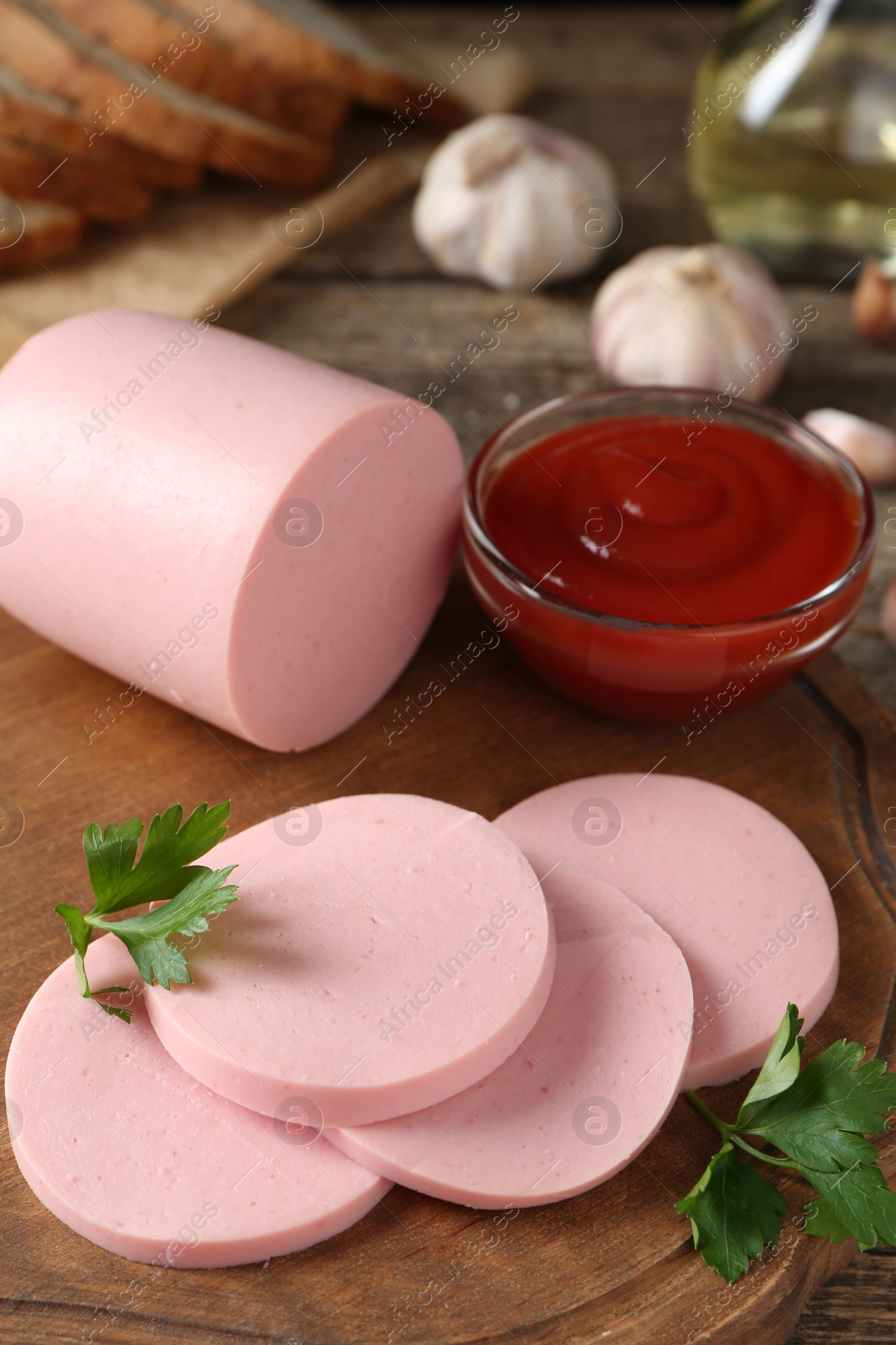 Photo of Tasty boiled sausage, ketchup and parsley on table, closeup