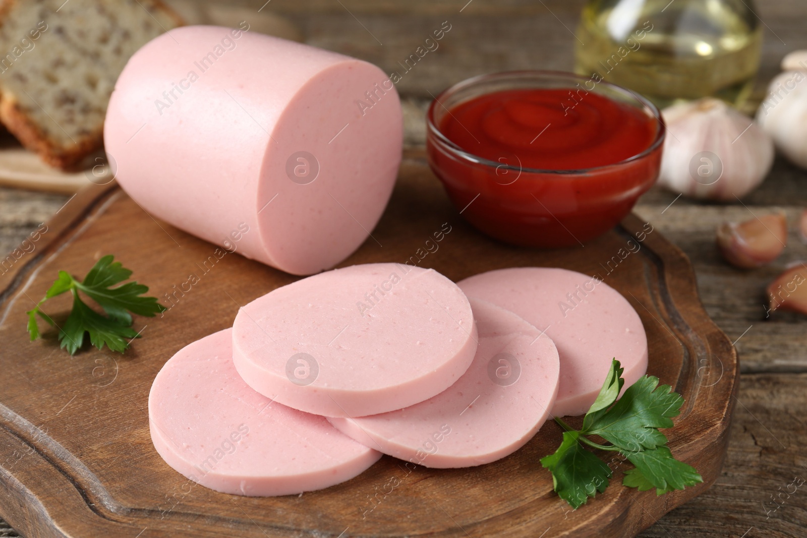 Photo of Tasty boiled sausage, ketchup and parsley on wooden table, closeup