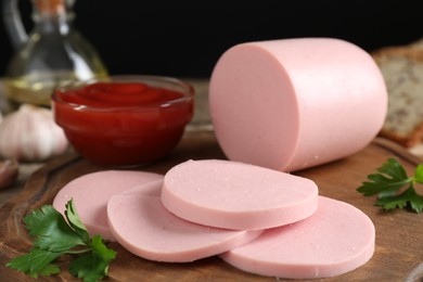 Photo of Tasty boiled sausage, ketchup and parsley on table, closeup