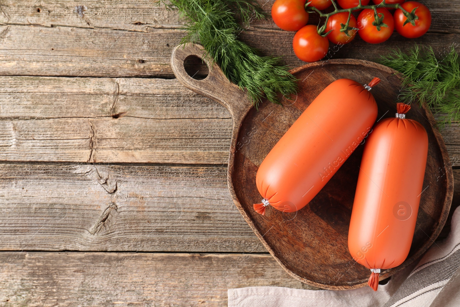 Photo of Tasty boiled sausages, tomatoes and dill on wooden table, top view. Space for text