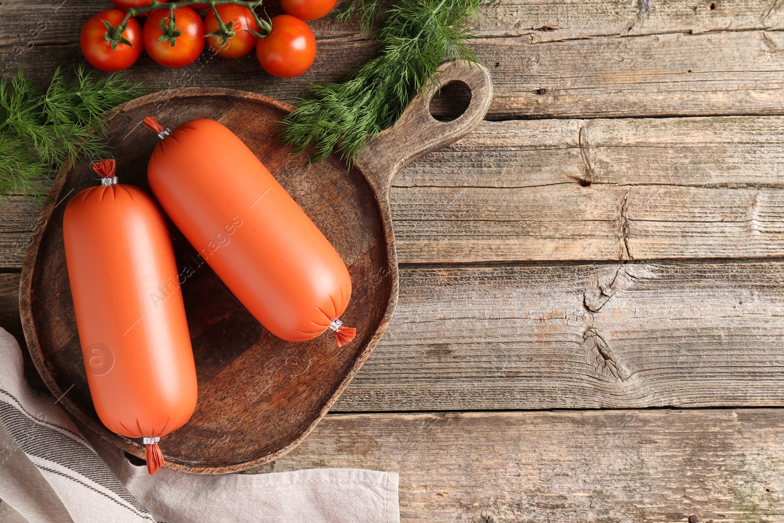 Photo of Tasty boiled sausages, tomatoes and dill on wooden table, top view. Space for text