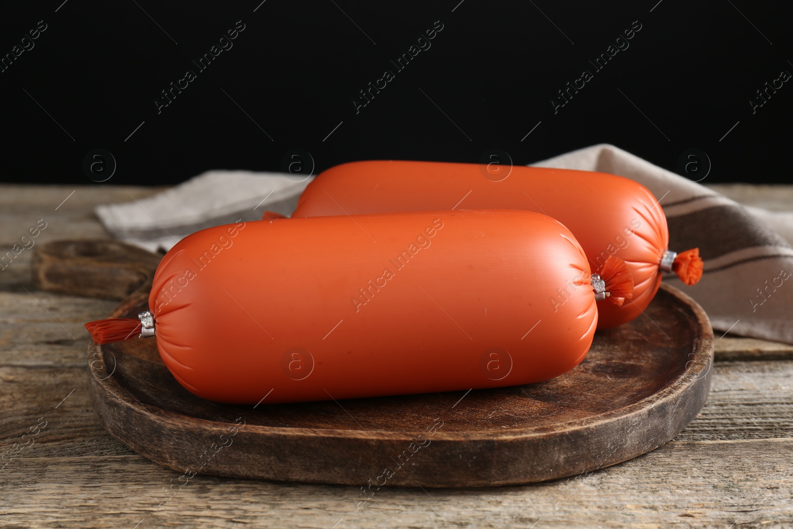 Photo of Tasty boiled sausages on wooden table, closeup