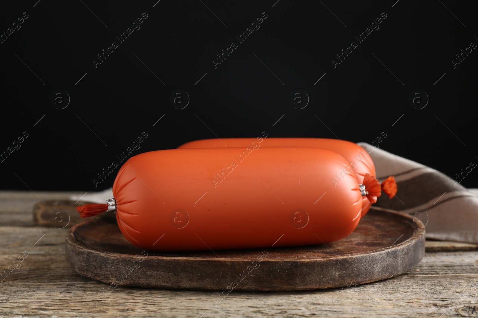 Photo of Two tasty boiled sausages on wooden table